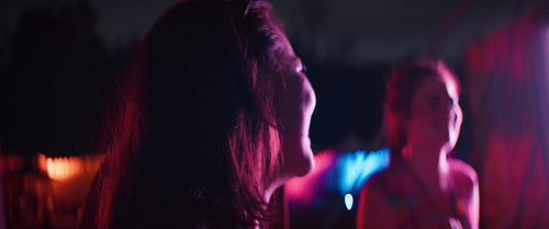 Young woman enjoying a music festival at night with friends