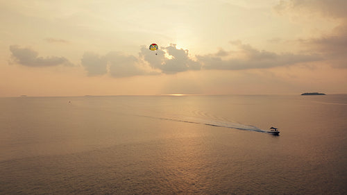 Stunning parasailing adventure over vast ocean waters at golden hour