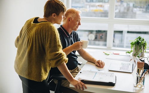 Creative professionals working together on laptop