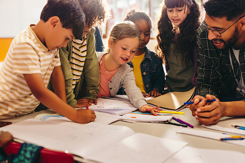 Group of children doing an art project with their teacher
