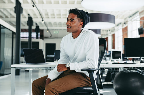 Young businessman looking away while sitting alone