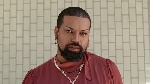 Bearded man in female outfit and makeup