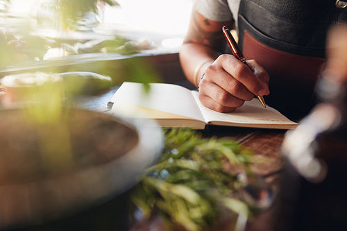 Barman writing new cocktail ideas.