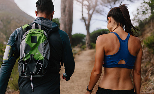 Fit young couple walking on mountain trail
