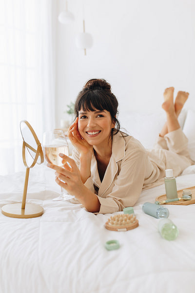 Smiling woman drinking wine after beauty care