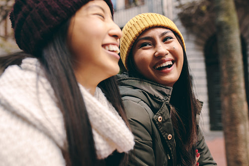 Cheerful asian women walking on street