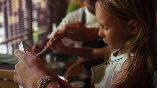 Mother and child learning to cook local cuisine on vacation