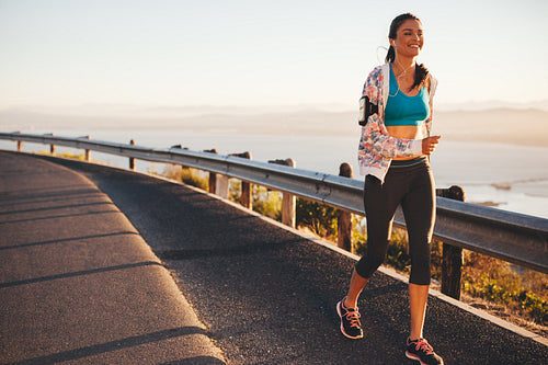 Happy young woman running on country road