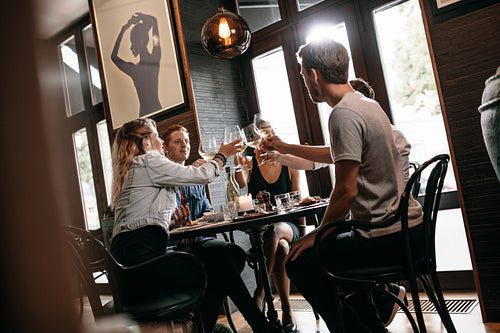 Group of friends toasting at restaurant