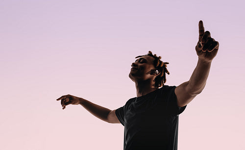 Energetic man dancing to music with eyes closed in studio silhouette