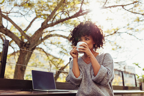 Woman drinking coffee outdoors