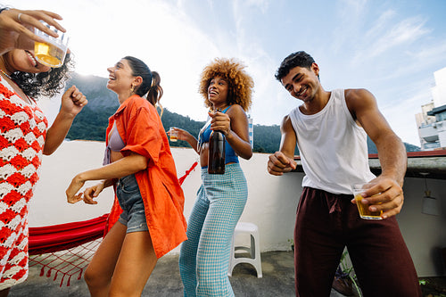 Friends enjoying a rooftop party celebrating together in summer