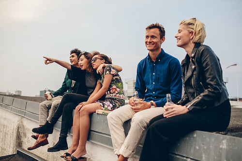Happy young friends relaxing on rooftop