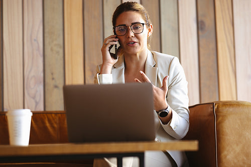 Professional woman talking on a phone call in a coworking office