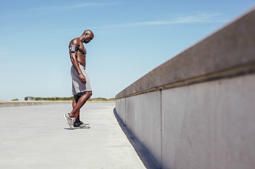 Shirtless young athlete relaxing after outdoor workout