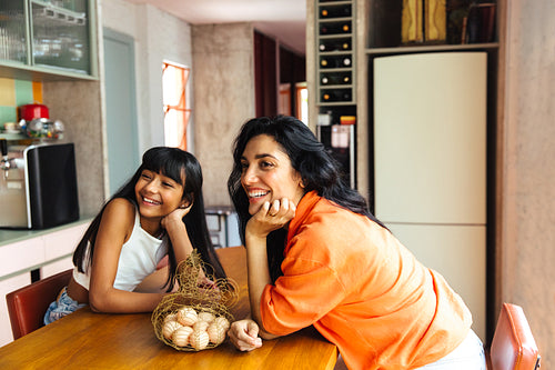 Mother and daughter smiling together in a modern kitchen setting