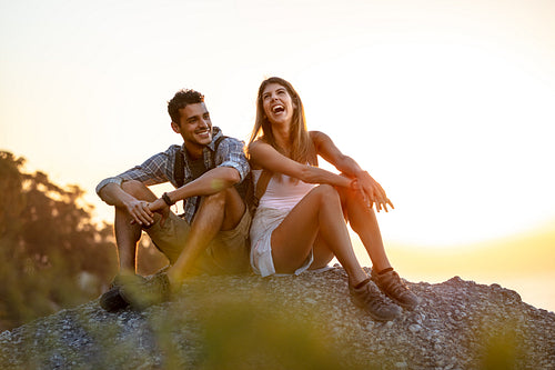 Laughing couple taking a break on a hike