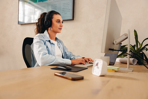 Businesswoman working at desk while using a computer in an office