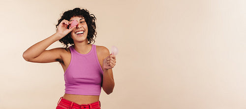 Happy young woman holding a menstrual cup and a menstrual disc