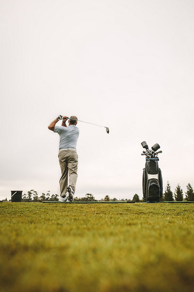 Senior man practicing his shots at driving range