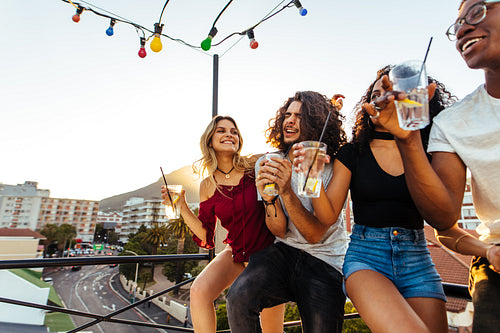 Young people partying on terrace with drinks