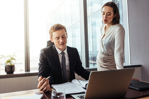 Businessman reading and discussing contract with colleague