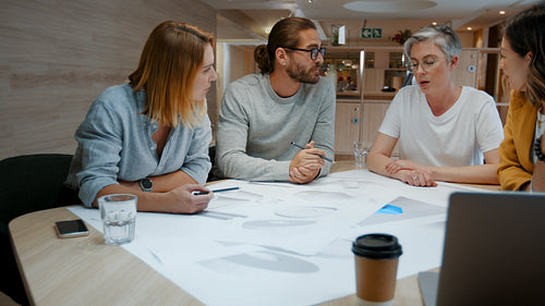Teamwork in action: Architectural designers sitting together and planning a project in an office