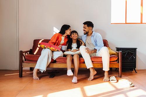 Happy Latino family enjoying quality time together on a cozy living room sofa