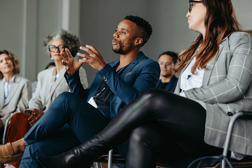 Black business man speaking at a workshop with colleagues in a conference setting