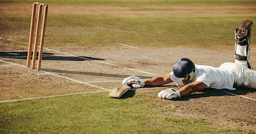 Cricketer dives to make ground during an intense match