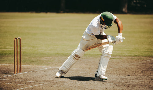 Cricket player batting on field during daytime game