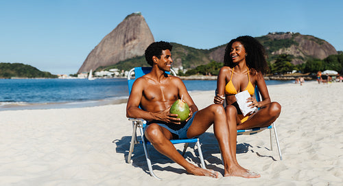 Friends enjoying a sunny beach day in Rio de Janeiro with snacks and laughter