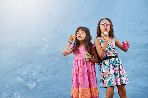 Adorable little girls blowing soap bubbles