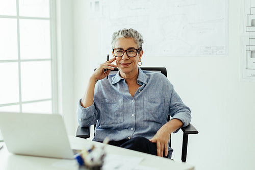 Senior graphic designer thinking carefully while sitting at her desk in an office