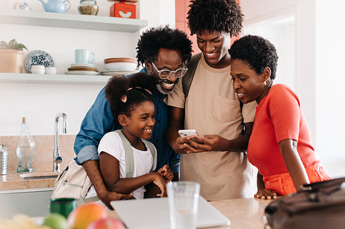 Teenage son using a smartphone with his family in the morning at home