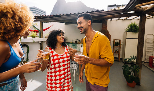 Friends enjoying rooftop drinks under a covered terrace in Rio de Janeiro