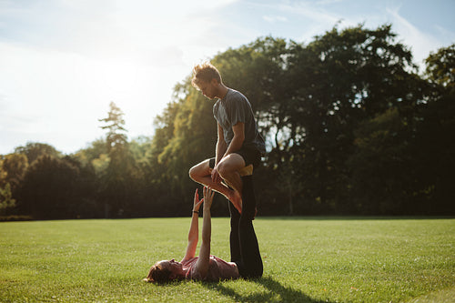 Couple in park practising pair acro yoga