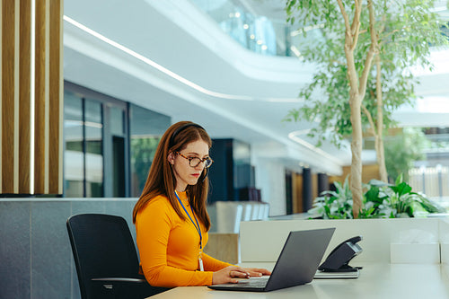 Corporate receptionist working at modern office desk