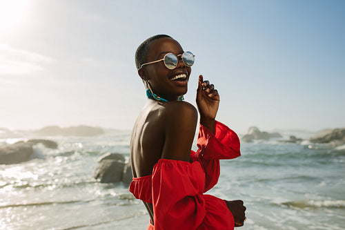 Attractive woman in red dress dancing on the beach