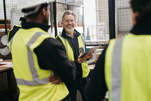 Senior warehouse worker having a meeting with his colleagues