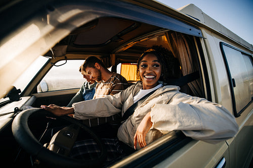 Friendly travelers in a van enjoying a sunny road trip together