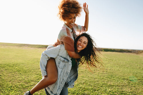Summer Break: Freedom outdoors with two girls enjoying playful moments on a sunny day on the green grass