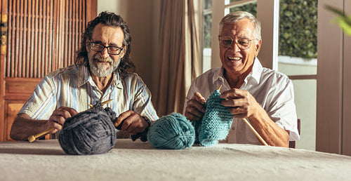 Retired men doing pastime at home knitting