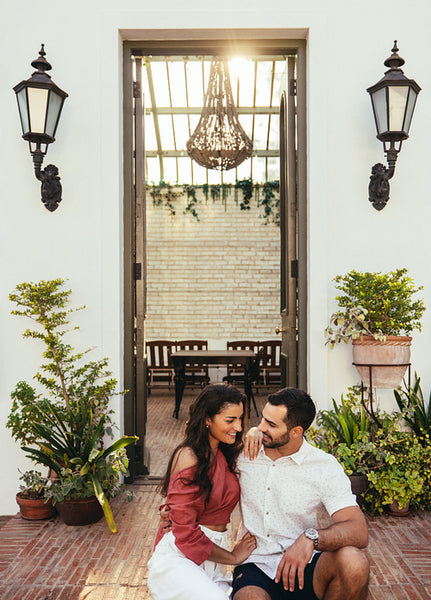 Tourist couple smiling at each other while sitting together