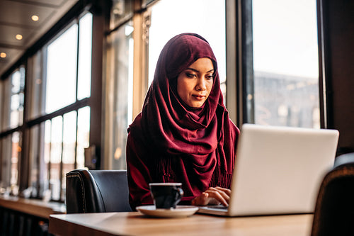 Businesswoman in hijab working from a coffee shop