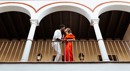 Couple kissing passionately on a balcony