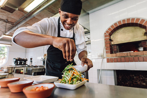 Male chef preparing salad in kitchen
