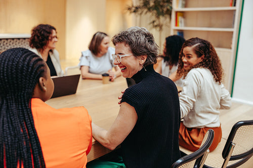 Multicultural employees smiling and interacting during a casual meeting