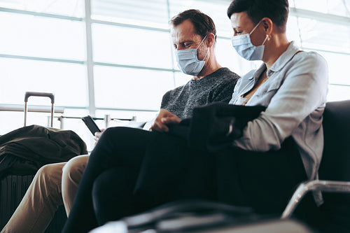 Couple with face masks waiting at airport