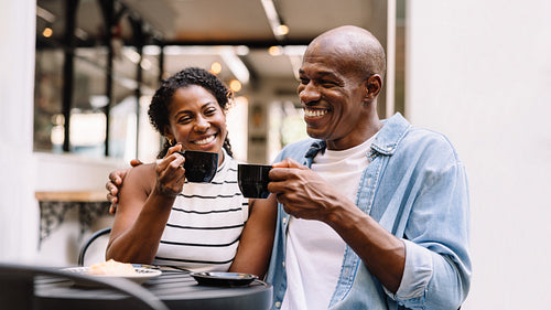 Happy couple laughing and enjoying coffee together